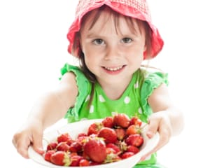 Cute little girl  with the  strawberry on a white background